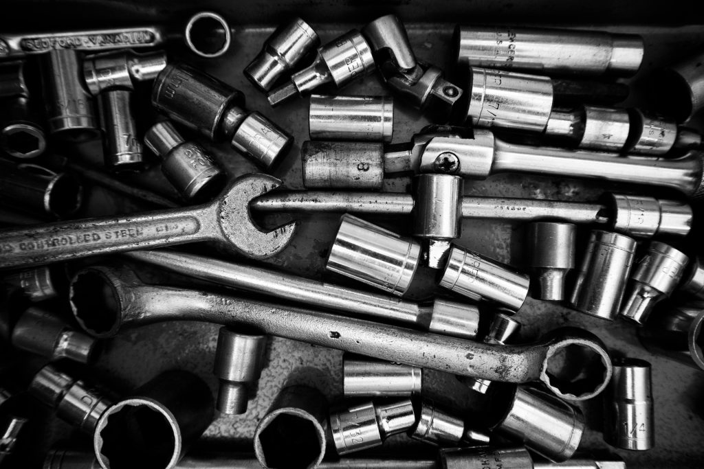 Grayscale image showcasing a variety of metal tools in a workshop setting. Perfect for industrial themes.